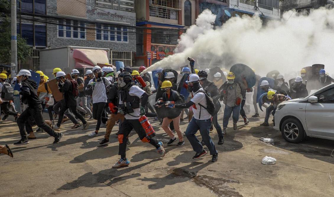 Demonstranter i Rangoon använder en brandsläckare mot militärens tårgas under onsdagens protester. Foto: STR/AP/TT