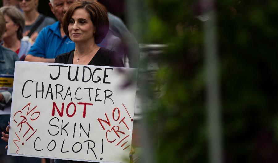 En kvinna håller upp en skylt under en demonstration mot kritisk rasteori (CRT) som lärs ut i skolor i Loudoun County Government Center i Leesburg, Virginia den 12 juni 2021. Foto: Andrew Caballero-Reynolds/AFP via Getty Images
