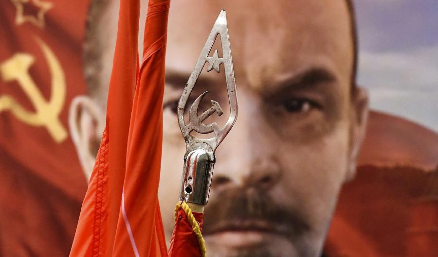 














Lenin, det kommunistiska Sovjetunionens förste ledare, syns på ett porträtt bakom en kommunistflagga, vid ett massmöte i Moskva 2017, för att uppmärksamma oktoberrevolutionens 100-årsdag. Foto: Kirill Kudryavtsev/AFP via Getty Images                                                                                                                                                                                                                                                                                                                                                                                                                                                                                                                                                                                                                                                                                    