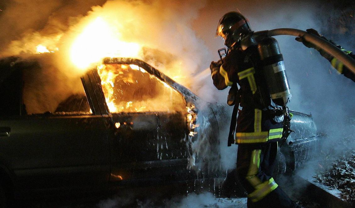 Brandmän släcker en utbränd bil i Strasbourg i östra Frankrike den 12 november 2005 efter att upplopp bröt ut runt om i landet. Foto: Olivier Morin/AFP via Getty Images