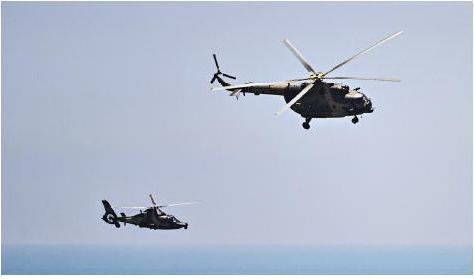 
Kinesiska militärhelikoptrar flyger utmed den kinesiska kusten under en militärövning i samband med USA:s talman Nancy Pelosis Taiwanbesök i augusti. Foto: Hector Retamal/AFP via Getty Images                                            