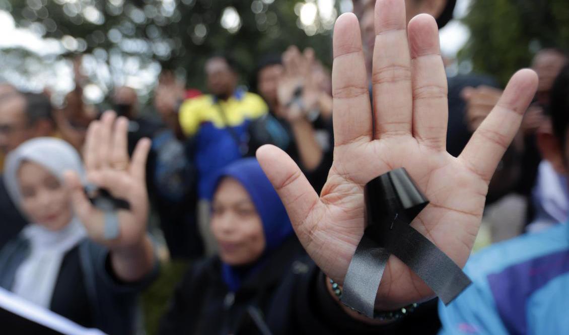 Kvinnor bär svarta rosetter som sorgesymbol för de 125 människor som förolyckades i samband med läktartragedin i Indonesien. Foto: Trisnadi/AP/TT