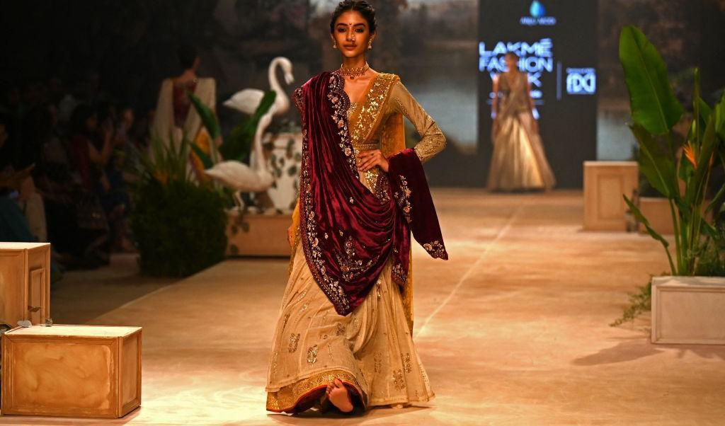 

En fotomodell visar upp en kreation av designern Anju Modi under en modevecka i Bombay ordnad av FDCI, The Fashion Design Council of India, och Lakme. Hon går på catwalken i en skapelse som har många lager och hon går med nakna fötter. Foto: Punit Pranjpe/AFP via Getty Images                                                                                        