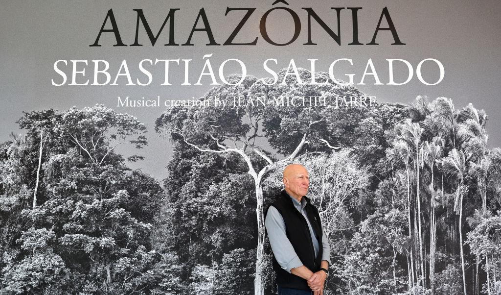 
Den brasilianska dokumentärfotografen Sebastião Salgado står vid sin utställning  Amazônia på California Science Center i Los Angeles. 200 storskaliga fotografier och videomontage tagna under sju år visar Amazonas regnskog, avlägsna inhemska stammar och avskogningen. Foto: Mario Tama/Getty Images                                            