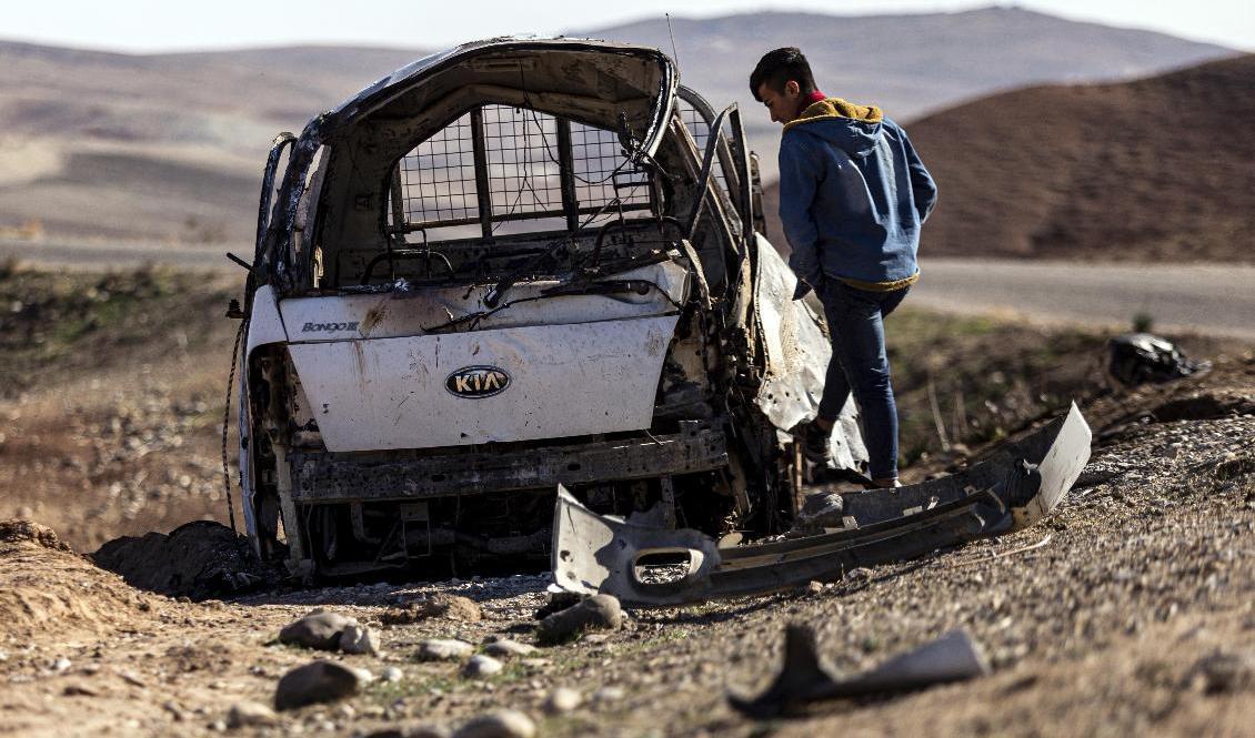En ung man studerar en bil som träffats av turkiska anfall vid byn Taql Baql i provinsen al-Hasakah, Syrien. Foto: Badrkhan Ahmad/AP/TT