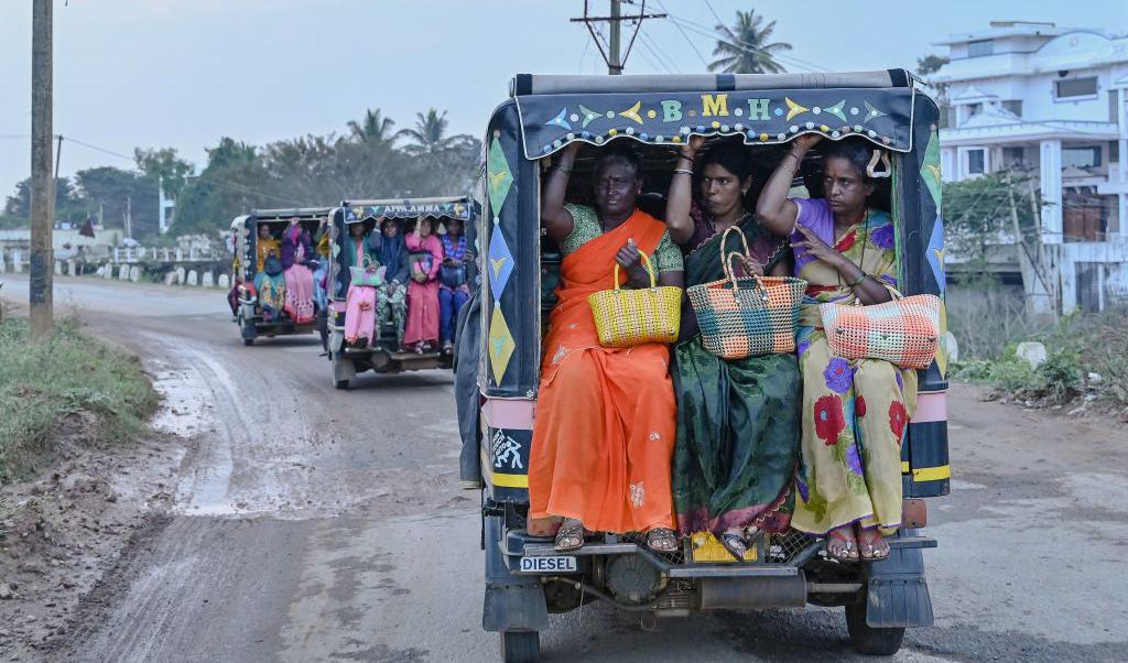 Kvinnor slutar sist arbete för dagen på en farm en bit från staden Bengalore, Indien. För att ta sig hem efter jobbet den 24 november 2022, åker de rickshaw som numera är motoriserade. Foto: Manjunath Kiran/AFP via Getty Images
