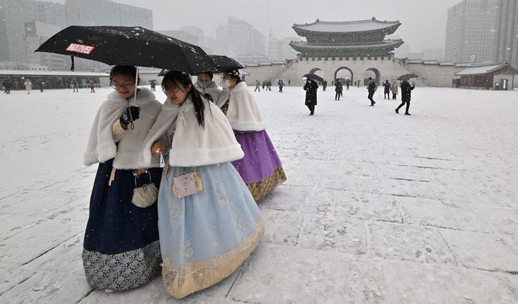 
Klädda i traditionella hanbok-kläder går besökare till Gyeongbokgung-palatset i Seoul, Korea, under ett snöfall den 15 december. Palatset byggdes 1395. Foto: Jung Yeon-je/AFP via Getty Images                                            