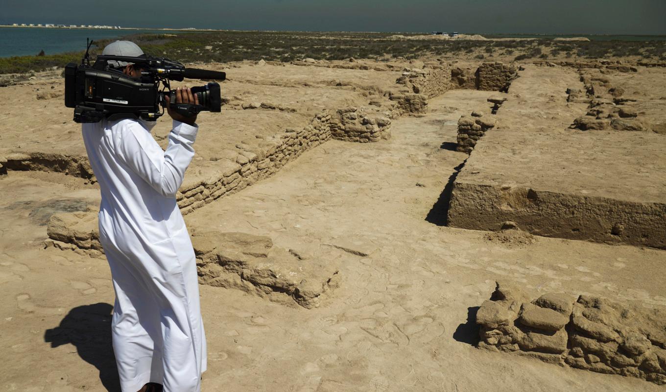 En journalist filmar ruinerna på Siniyah Island i Umm al-Quwain, där arkeologer säger att de har hittat den äldsta pärlstaden i Persiska viken hittills. Foto: Jon Gambrell/AP/TT