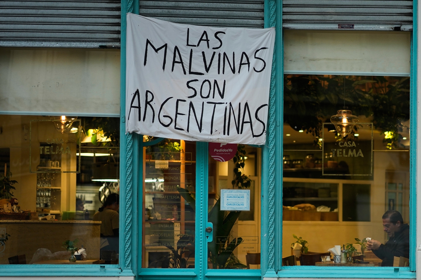 ”Las Malvinas är argentinska”, lyder en banderoll på en restaurang i Buenos Aires. Islas Malvinas är det spanska namnet på Falklandsöarna. Foto: Natacha Pisarenko/AP/TT