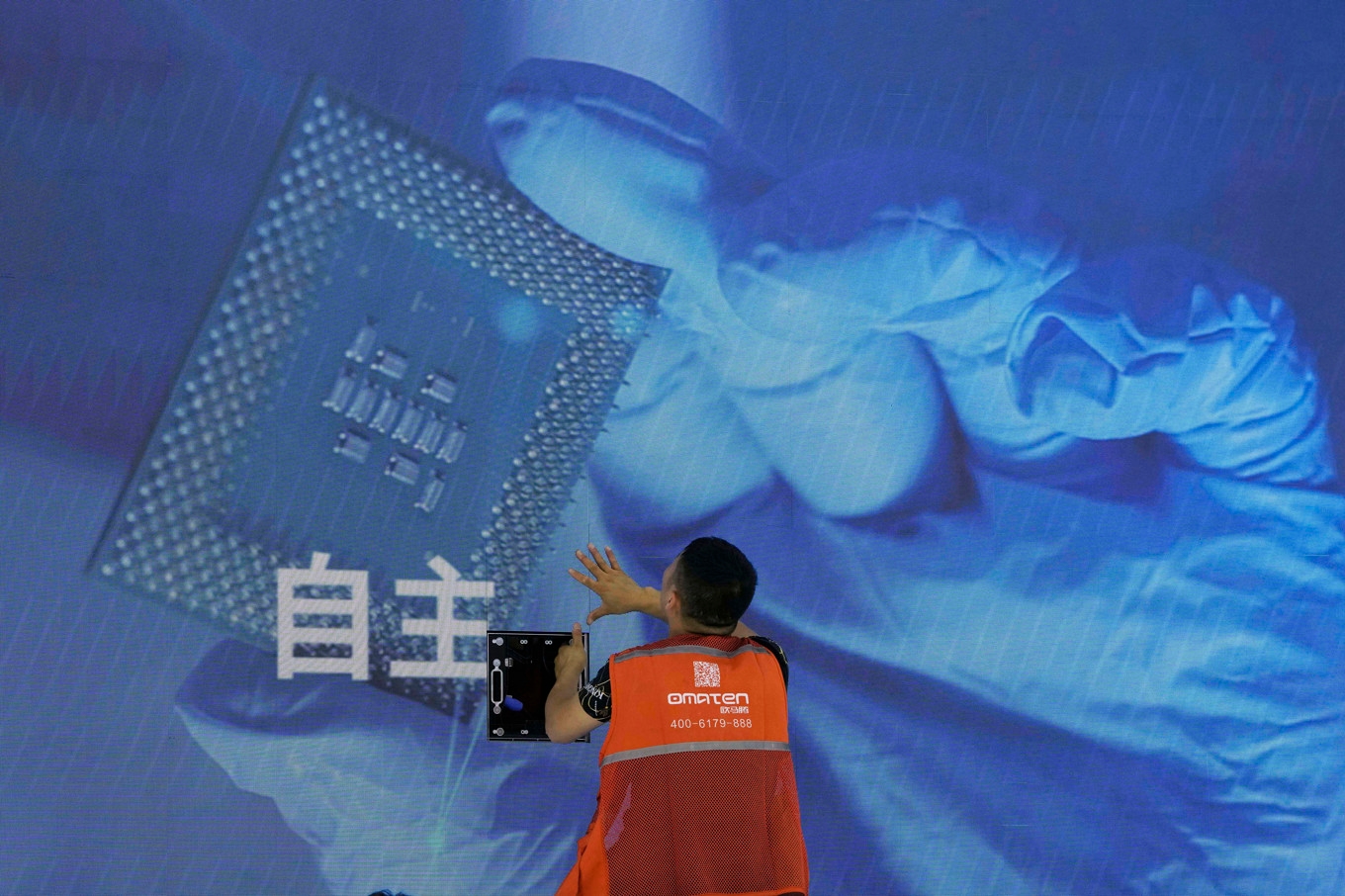 AI-branschens jakt på minneschip har drivit upp priserna och begränsat tillgången. På bilden kollar en arbetare skärmarna vid en AI-mässa i Shanghai. Arkivbild. Foto: Ng Han Guan/AP/TT