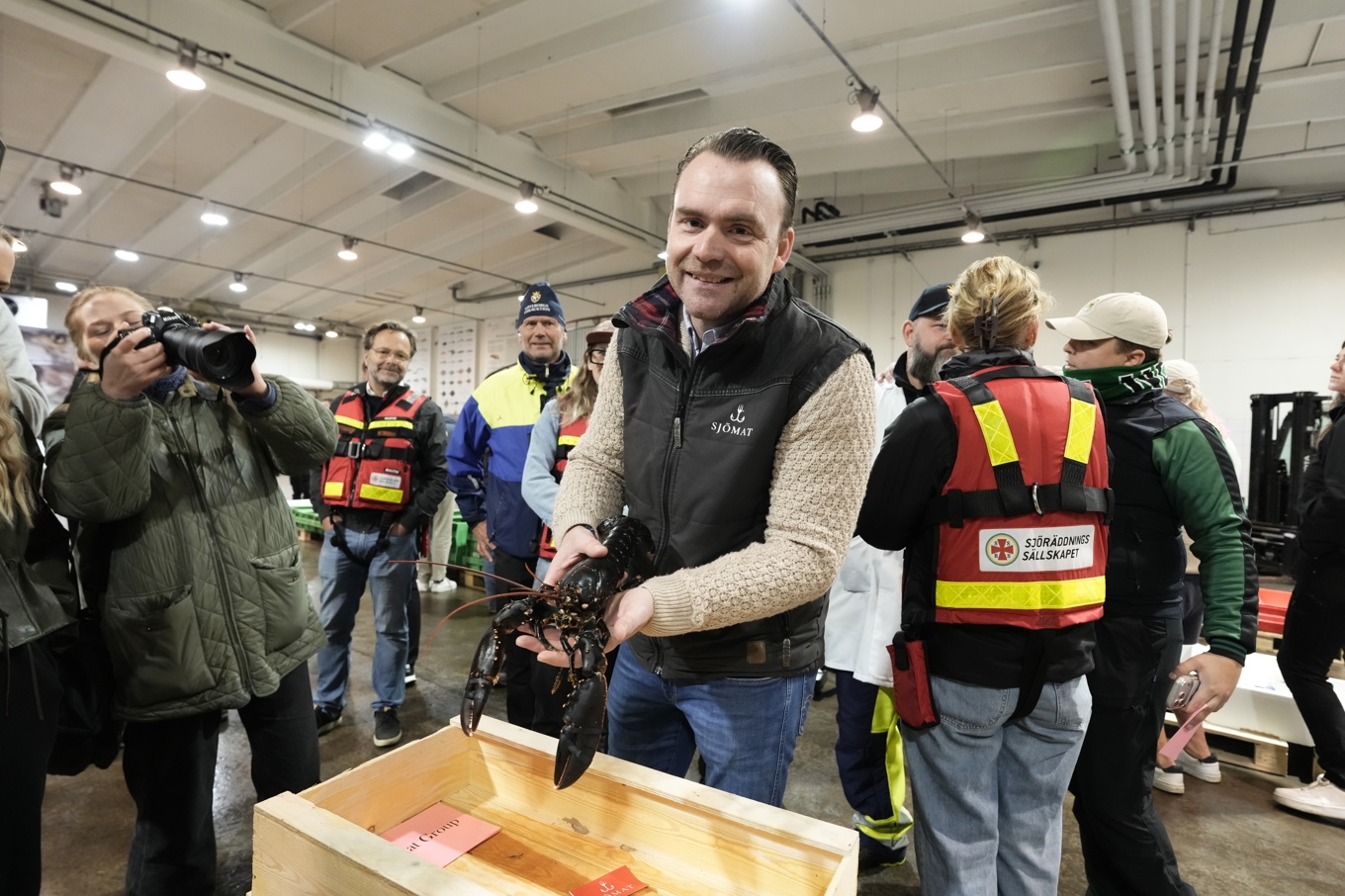 Nu har årets första hummer auktionerats ut i Göteborg – för 53 000 kronor kilot. Köparen Tobias Linder visar upp hummern. Foto: Björn Larsson Rosvall/TT