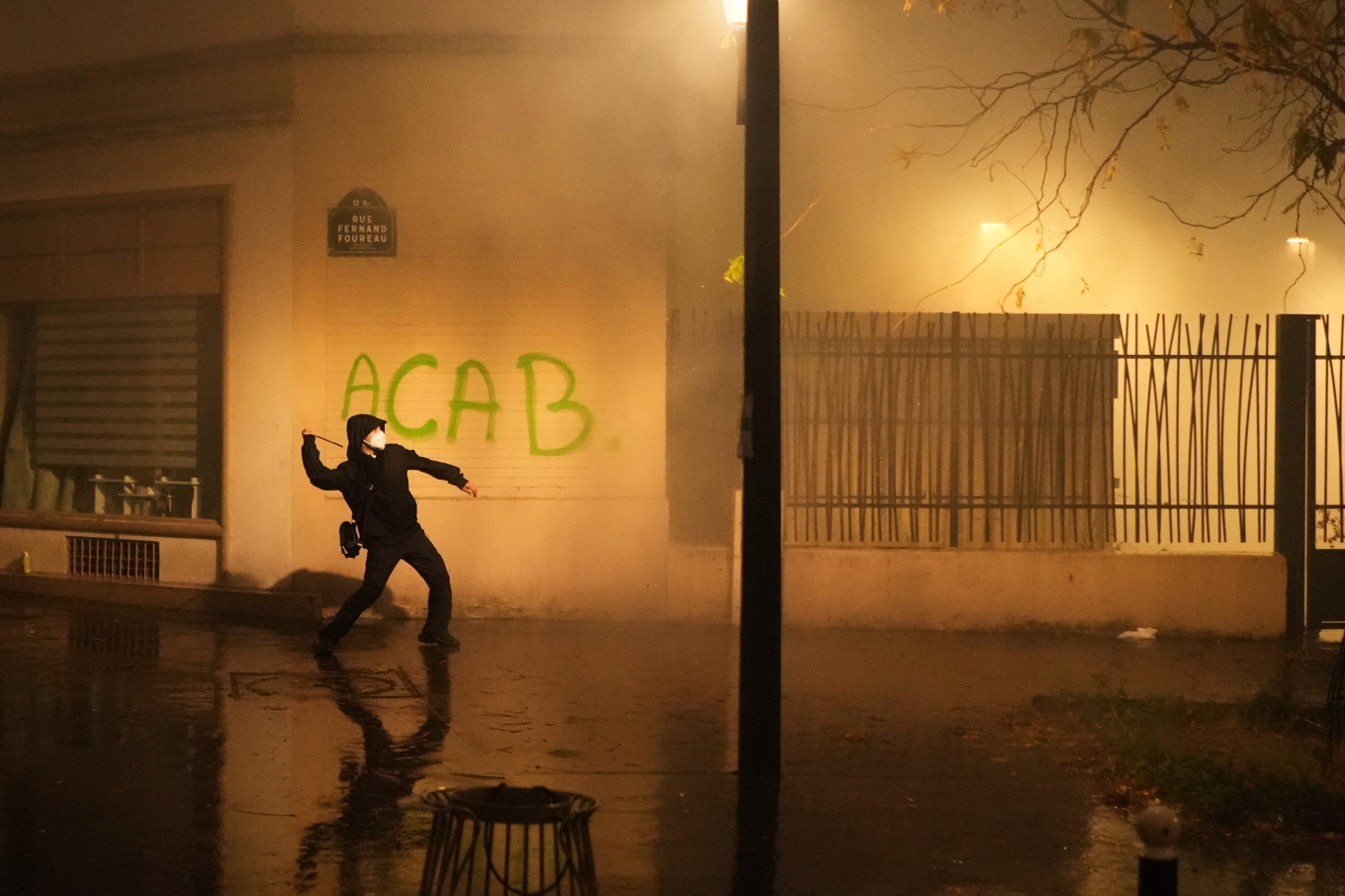 En demonstrant kastar ett föremål mot polis under lördagens protester i Paris. Foto: Thibault Camus/AP/TT